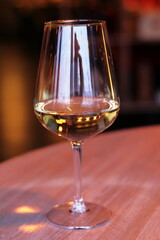 A glass of white semi-sweet wine on the table.
