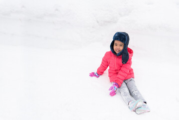 Fototapeta na wymiar Happy girl plays with a snow in sunny winter day