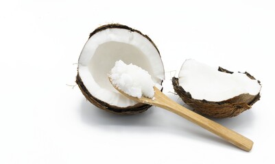 Healthy food concept, A wooden spoon with coconut oil in solid state next to a halved coconut on...