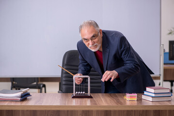 Old teacher physicist sitting in the classroom