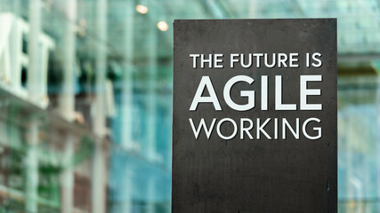 The future of work is Agile sign in front of a modern office building