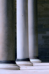 Three columns made of marble of a medieval building standing tall at a courtyard in a cool sunny...