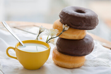 delicious sugary chocolate donuts with cup of milk