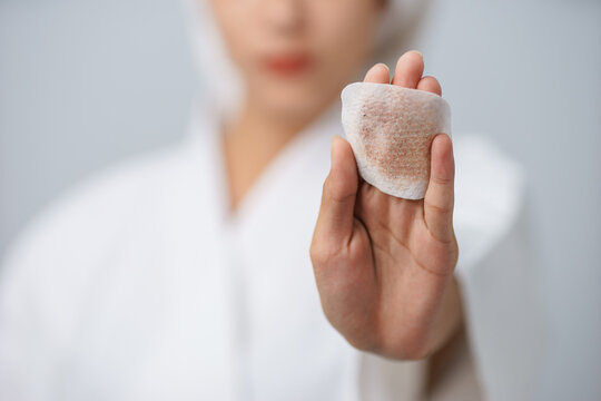 Close-up hand of young woman to show cosmetic pad after using remove makeup cares for face skin with copy space.