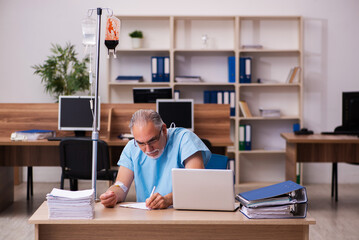 Old male employee in blood transfusion concept