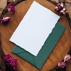 Wedding Flat lay. Wedding invitation set with card mockups for instagram. Wedding set with a dark green envelope and an invitation form on a wooden background with bush rose flowers. place for text