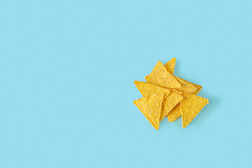 Naklejka premium Traditional Mexican Nachos, corn tortilla chips on blue background. Flat lay composition, Copy space, minimalism.