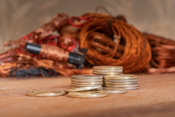 Stacks of gold coins on a background of copper and electrical waste.