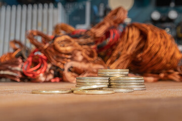 Stacks of gold coins on a background of copper and electrical waste.