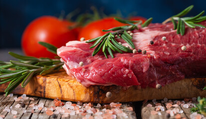 Raw beef steak close-up, with rosemary on a background with vegetables. Meat Recipes, Recipe Book, Selling Meat in Market or Store on Banner