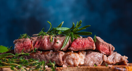 cooked steak medium rare close-up, with rosemary on a background with vegetables.Tasty...