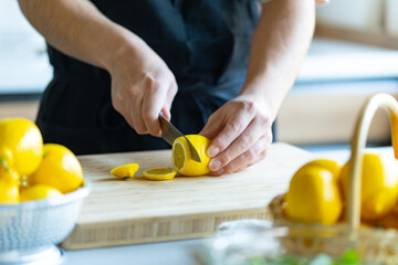 Woman cutting lemons in kitchen.

