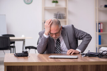 Aged male employee suffering at workplace