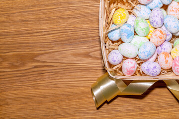 easter colorful eggs in a nest close up on a wooden background