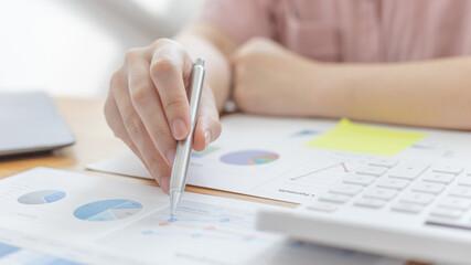 Naklejka premium Businessmen working in the office using the expense and budget accounting calculator with graphs as a measure of the company's growth, financial and accounting concepts.