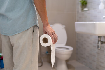 Men are standing in front of the bathroom door using their hands to hold the abdomen with severe...