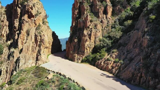 La route des calanques de Piana en Corse, avec des rochers la surplombant