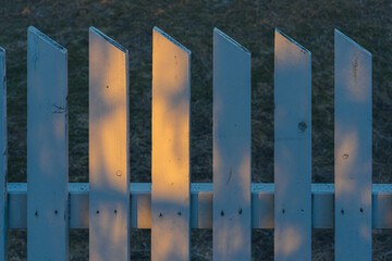 Picket fence hit by the first morning light in spring.