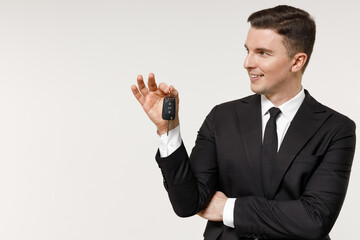 Young rich employee business corporate lawyer man in classic formal black grey suit shirt tie work in office hold car keys fob keyless system look aside isolated on white background studio portrait