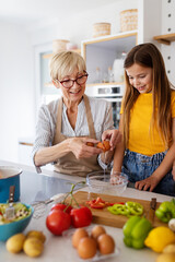 Grandmother and granddaughter are cooking on kitchen. Family fun love generation concept