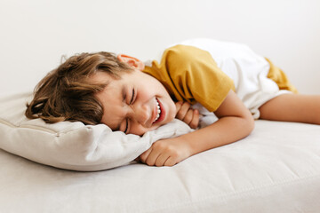 Cute boy lying on sofa and smiling