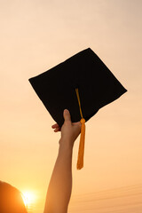 Graduates wear a black hat to stand for congratulations on graduation Silhouette at sunset