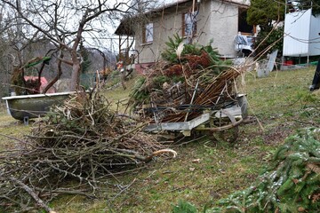 Cleaning the lawn in the garden from fallen branches and dry leaves in spring 