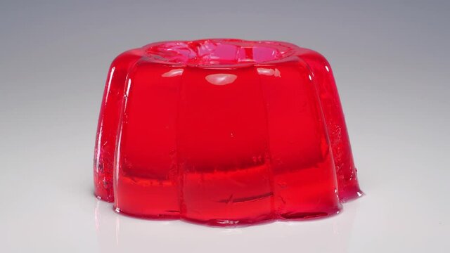 Wobbly single red jelly on white background.