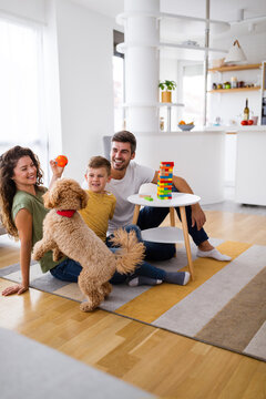 Happy Family Having Fun Time, Playing Together At Home With Dog