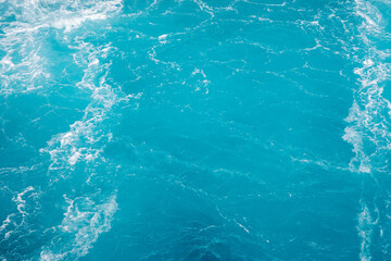 Surface of the sea. Natural texture of blue foaming sea water. Turquoise ocean water background.