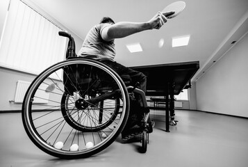 Disabled man in a wheelchair play at table tennis. Tennis balls fixed in a wheel