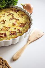 French onion pie with bacon in a baking dish, copy space. Authentic hobby homemade cakes, jellied pie with onions