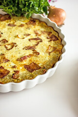 French onion pie with bacon in a baking dish, copy space. Authentic hobby homemade cakes, jellied pie with onions