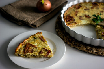 Slice of French onion pie on a white plate with a fork