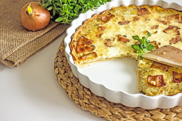 French onion pie with bacon in a baking dish, copy space. Authentic hobby homemade cakes, jellied pie with onions