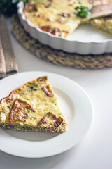 Slice of French onion pie on a white plate with a fork