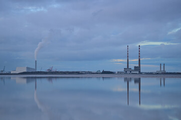 Dublin Waste to Energy (Covanta Plant), Poolbeg CCGT and Pigeon House Power Station view from Blackrock Beach, Dublin, Ireland. Beautiful evening view with reflection in the water