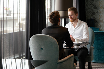 Successful businessman smiling while discussing with partner during meeting at coffee break