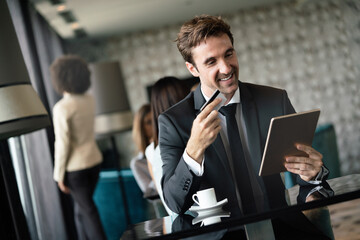 Portrait of happy successful businessman holding tablet