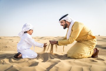 Arabian man and son playing in the desert