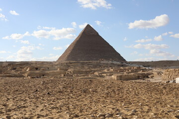 Fototapeta na wymiar The great pyramids of giza. Tourists in the historic city. Beautiful landscape on a sunny day. View of walking people on a cloudy morning. Travel to African continent. UNESCO World Heritage Site.