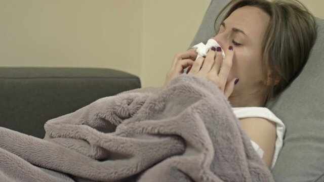 Young woman has a cough, chills, runny nose. Flu symptoms, colds. Possible side effects of the coronavirus vaccines.