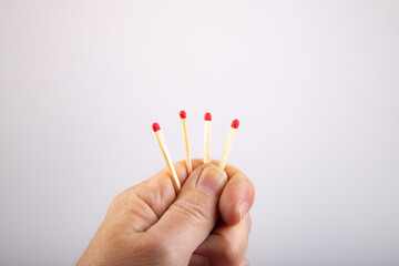 vier Streichhölzer in einer Hand, einer ist kürzer, als Symbol für den Kürzeren ziehen, das...