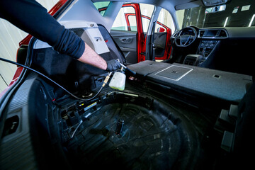 A car service worker cleans interiror with a special foam generator