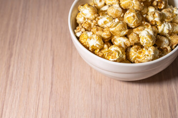 a cup of popcorn on a wooden background . place for the label