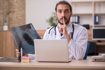 Young male doctor radiologist sitting in the office