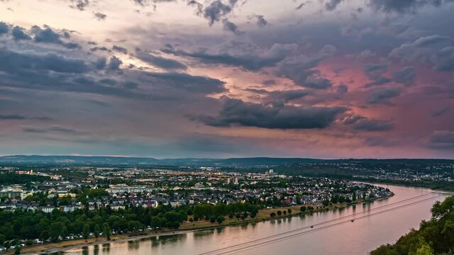 Dark clouds floating above city by river at dusk, time lapse of German city