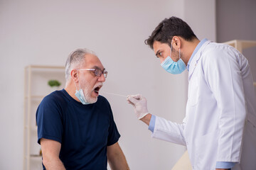 Fototapeta premium Old male patient visiting young male doctor otorhinolaryngologis