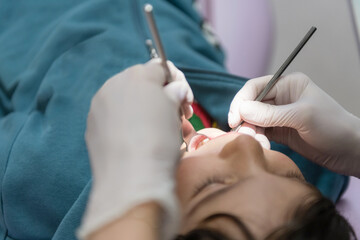Dentist examining young boy's teeth in clinic