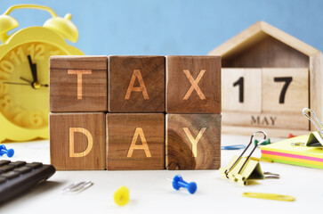 Tax Day concept with wooden calendar 17 May and wooden cube